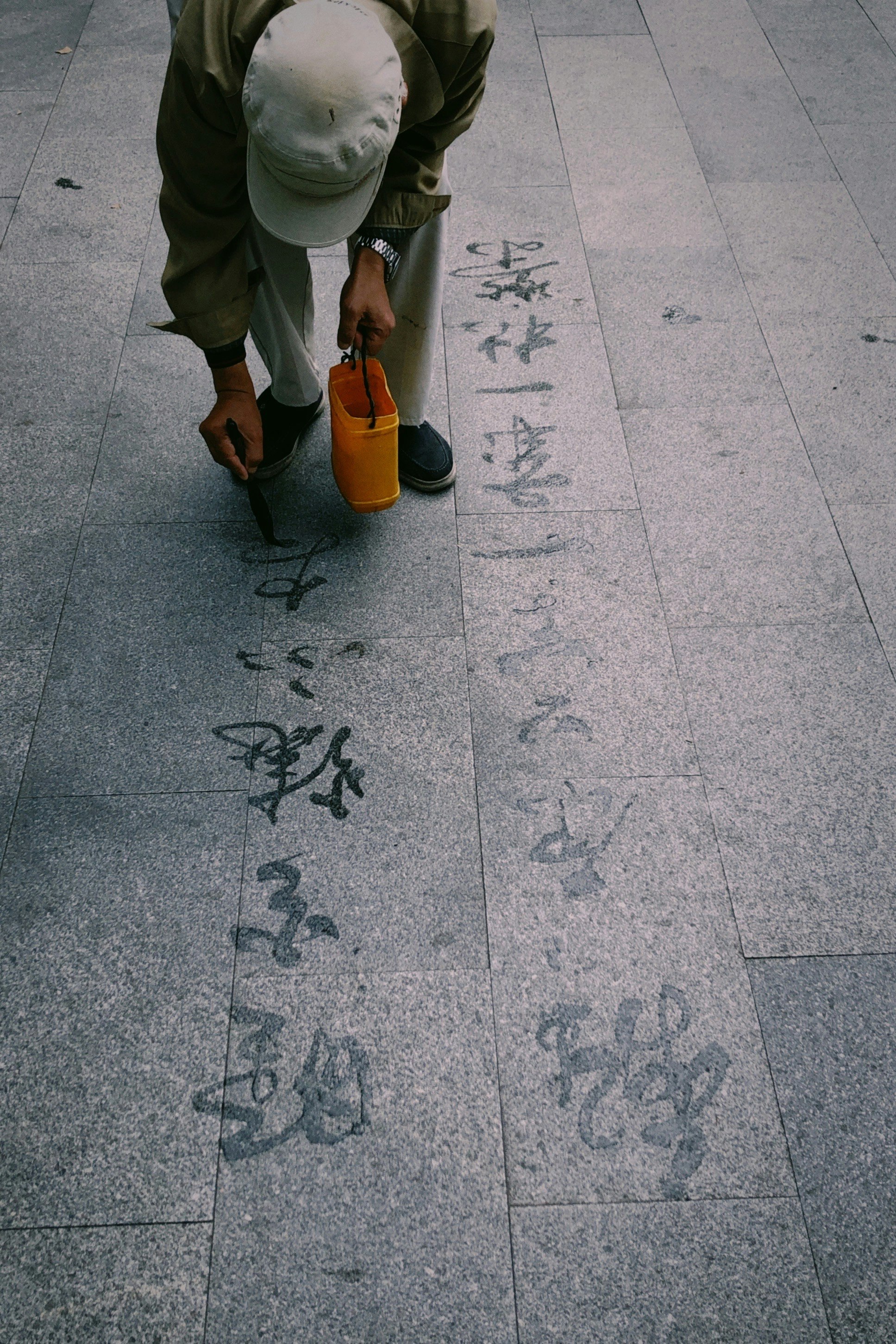 person in brown pants and brown shoes standing on gray concrete floor